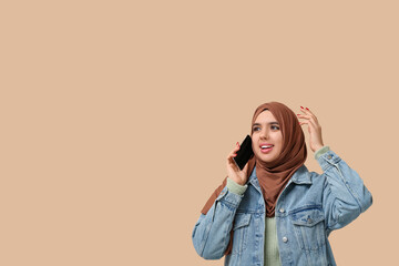 Sticker - Beautiful young Muslim woman in hijab talking by mobile phone on beige background