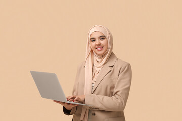 Sticker - Beautiful young Muslim woman in hijab with modern laptop on beige background