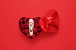 Leinwandbild Motiv Gift box with beautiful rose flowers and vibrator on red background