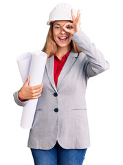 Poster - Beautiful young woman wearing architect hardhat holding build project smiling happy doing ok sign with hand on eye looking through fingers