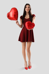 Sticker - Beautiful young woman with heart-shaped air balloon and gift for Valentine's day on grey background