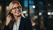 © Ruslan - A portrait shows a cheerful blonde businesswoman speaking on her phone while holding a folder and smiling. she's dressed in a white shirt and black jacket, and she works in a modern office