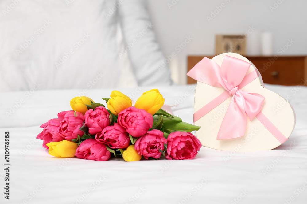 Tulips with gift box on bed, closeup. International Women's Day celebration