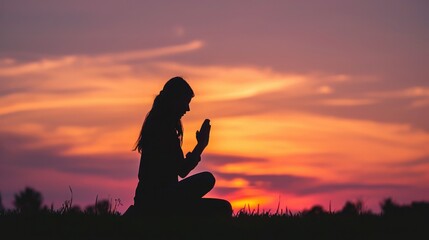 Wall Mural - Silhouette of woman kneeling down praying for worship God at sky background. Christians pray to jesus christ for calmness. In morning people got to a quiet place and prayed. copy space