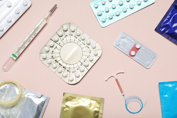 Wall Mural - Contraceptive pills, condoms, intrauterine device and thermometer on beige background, flat lay. Different birth control methods