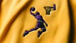 Broderie sur tissu jaune : Basketteur en plein saut