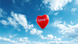  A red heart shaped balloon with the word love written on it in front of a blue sky with white clouds