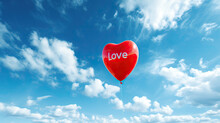  A Red Heart Shaped Balloon With The Word Love Written On It In Front Of A Blue Sky With White Clouds
