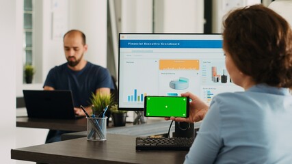 Poster - office worker looks at greenscreen on smartphone display app, analyzing isolated chromakey layout on