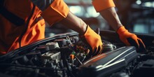 Black Mechanic Wearing Orange Coveralls Fixing A Car Engine