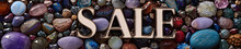 A Stunning Collection Of Diverse Gemstones And Crystals, Surrounding The Metallic, Three-dimensional Text "SALE", Creating A Vibrant And Attractive Advertisement.