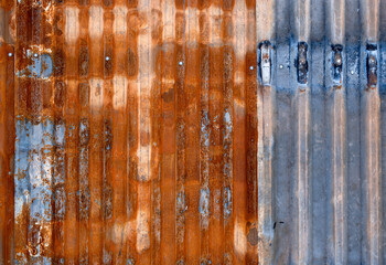 The surface of a rusty corrugated sheet of iron in close-up.