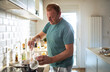 © Marko Geber - Middle aged caucasian man cooking at home in the kitchen