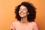 Fototapeta  - Portrait of a happy young african american woman on orange background