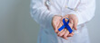 © Jo Panuwat D - March Colorectal Cancer Awareness month, doctor with dark Blue Ribbon for supporting people living and illness. Healthcare, hope and World cancer day concept
