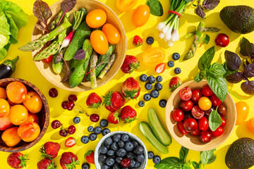 Wall Mural - Different berries and vegetables on a bright yellow background. Top view.