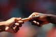 A close-up image showing one person handing an object to another person, Close-up of a baton pass in a relay race, AI Generated