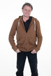 © OceanProd - smiling cheerful middle aged mature man clothes brown sweatshirt hands hoodie pockets on white background