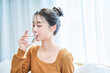 © maru54 - 部屋で水を飲む若い女性