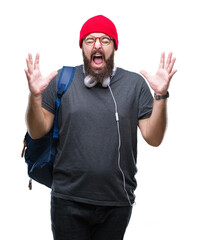 Sticker - Young hipster man wearing red wool cap and backpack over isolated background celebrating mad and crazy for success with arms raised and closed eyes screaming excited. Winner concept