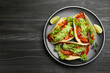 Delicious tacos with guacamole, meat and vegetables on wooden table, top view. Space for text
