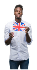 Poster - Young african american man holding United Kingdom flag with a confident expression on smart face thinking serious