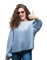 Poster - Beautiful brunette curly hair young girl wearing sunglasses over isolated background doing happy thumbs up gesture with hand. Approving expression looking at the camera with showing success.