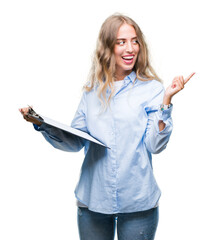 Wall Mural - Beautiful young blonde business woman holding clipboard over isolated background very happy pointing with hand and finger to the side