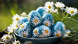 Blue Easter eggs with a print of daisies lie in the green grass