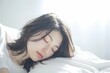 ベッドで寝ている日本人女性のポートレート（睡眠・うたたね・寝る・快眠・休息）