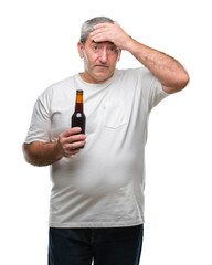 Sticker - Handsome senior man drinking beer bottle over isolated background stressed with hand on head, shocked with shame and surprise face, angry and frustrated. Fear and upset for mistake.