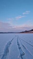 Wall Mural - Calm winter scene on the frozen lake covered with snow