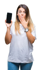 Wall Mural - Young beautiful woman showing blank screen of smartphone over isolated background cover mouth with hand shocked with shame for mistake, expression of fear, scared in silence, secret concept