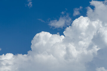 Fluffy white cumulus clouds in a blue sky on a beautiful day, natural soft background with copy space for text