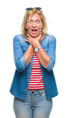 Wall Mural - Middle age blonde woman over isolated background shouting and suffocate because painful strangle. Health problem. Asphyxiate and suicide concept.