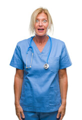 Sticker - Middle age blonde nurse surgeon doctor woman over isolated background afraid and shocked with surprise expression, fear and excited face.