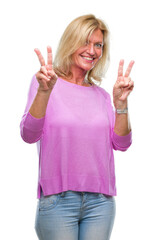 Sticker - Middle age blonde woman over isolated background smiling looking to the camera showing fingers doing victory sign. Number two.