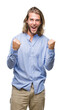 © Krakenimages.com - Young handsome man with long hair over isolated background celebrating surprised and amazed for success with arms raised and open eyes. Winner concept.