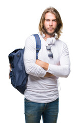 Canvas Print - Young handsome tourist man with long hair wearing backpack over isolated background skeptic and nervous, disapproving expression on face with crossed arms. Negative person.