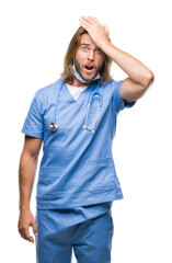 Sticker - Young handsome doctor man with long hair over isolated background surprised with hand on head for mistake, remember error. Forgot, bad memory concept.