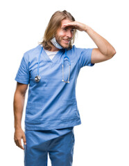 Poster - Young handsome doctor man with long hair over isolated background very happy and smiling looking far away with hand over head. Searching concept.