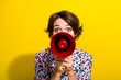 Photo of impressed lady hands hold communicate loudspeaker cover mouth isolated on yellow color background