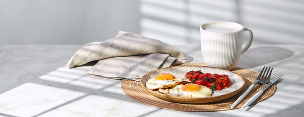 Wall Mural - Breakfast with fried eggs and fried tomatoes with spinach on plate and cup of latte coffee