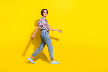 Sticker - Full length profile photo of cute positive person walking empty space isolated on bright yellow color background