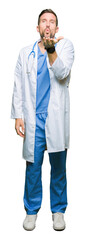 Poster - Handsome doctor man wearing medical uniform over isolated background looking at the camera blowing a kiss with hand on air being lovely and sexy. Love expression.