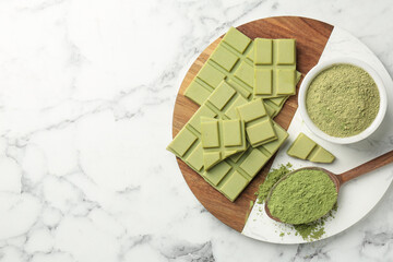 Wall Mural - Pieces of tasty matcha chocolate bar and powder on white marble table, top view. Space for text