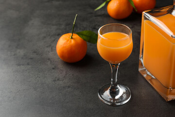 Canvas Print - Delicious tangerine liqueur and fresh fruits on grey table, space for text