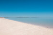 © Austockphoto - a peaceful beach with white sand and calm blue water