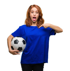 Sticker - Young beautiful woman over isolated background holding soccer football ball with surprise face pointing finger to himself