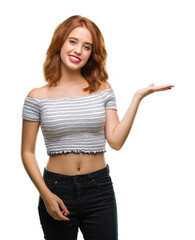 Sticker - Young beautiful woman over isolated background smiling cheerful presenting and pointing with palm of hand looking at the camera.